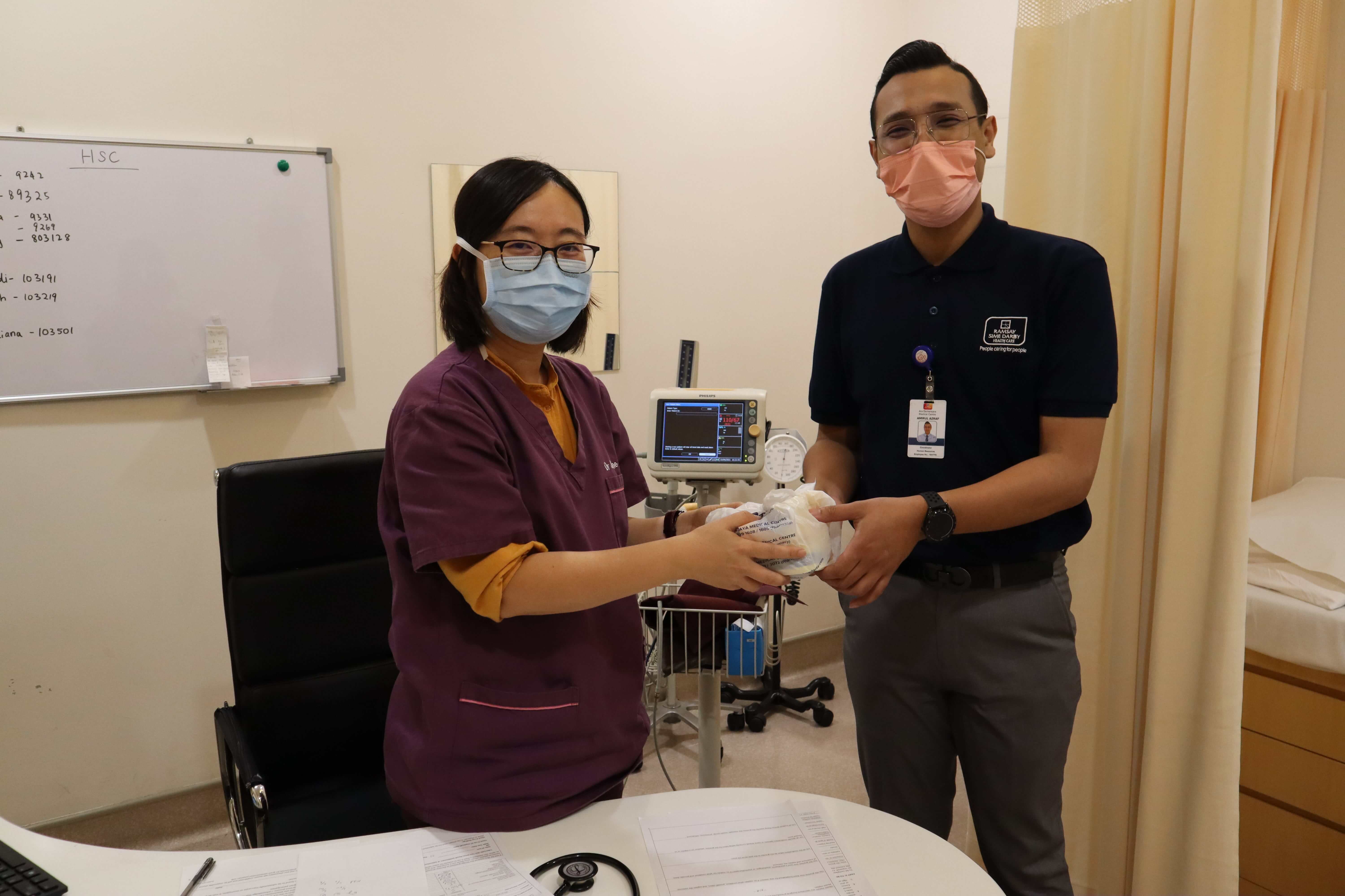 Staff giving out bubur lambuk to ADMC Drs